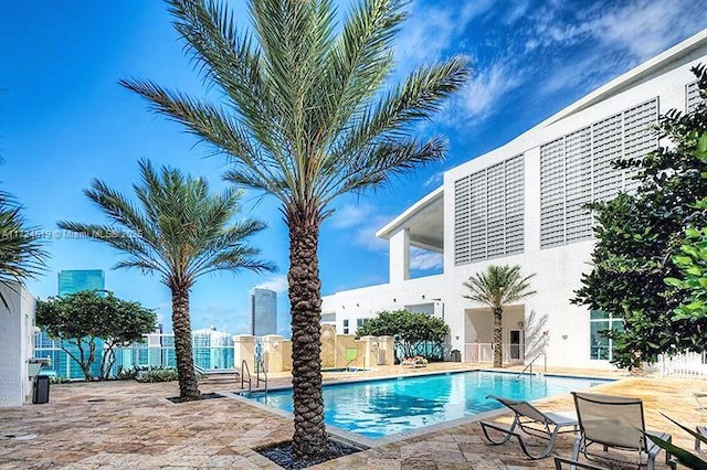 pool with a patio and fence