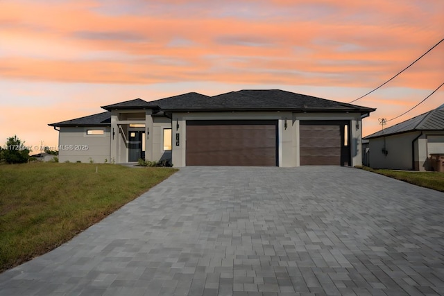 prairie-style house featuring a yard and a garage