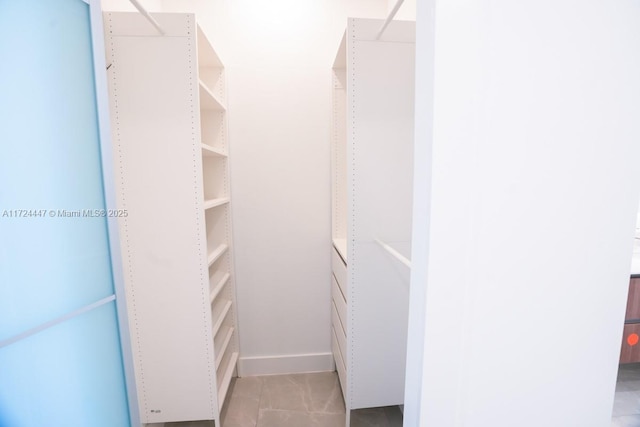 spacious closet with light tile patterned floors