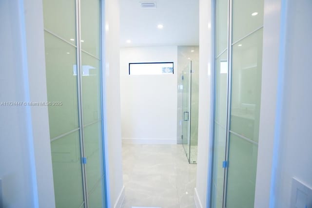 bathroom featuring a shower with door