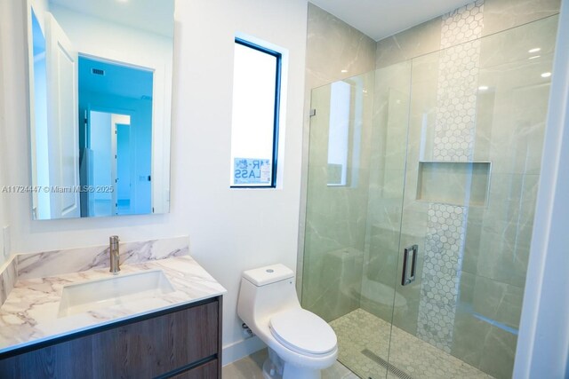 bathroom with an enclosed shower, vanity, and toilet