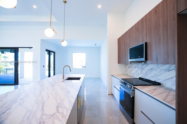 kitchen with light stone counters, pendant lighting, stainless steel electric stove, backsplash, and sink