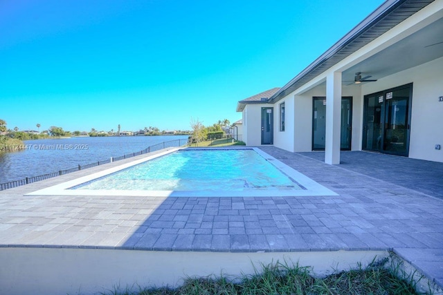 view of swimming pool with a water view, ceiling fan, and a patio