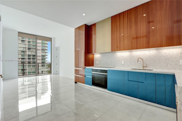 kitchen featuring sink, light tile patterned flooring, tasteful backsplash, and black appliances