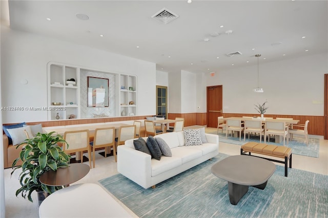 living room with wooden walls and built in shelves