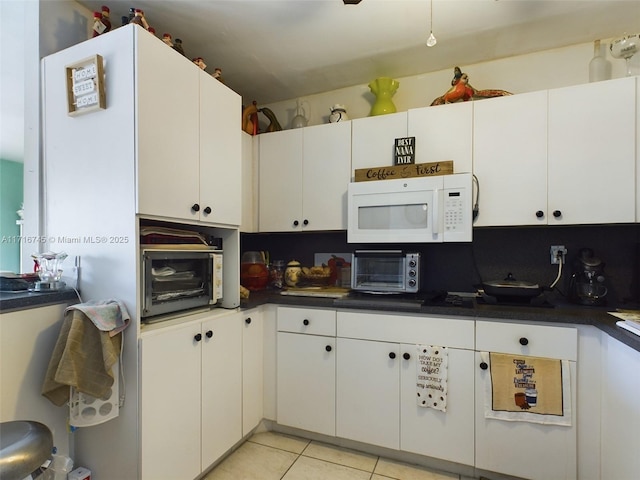 kitchen with light tile patterned flooring and white cabinetry