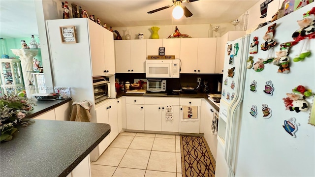 kitchen with light tile patterned floors, white cabinetry, and white appliances