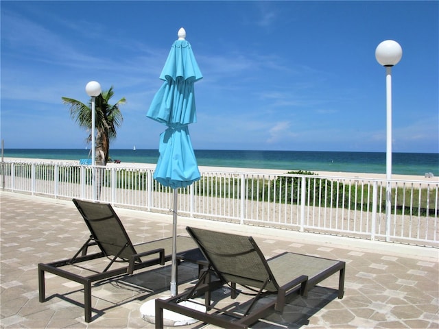 view of patio / terrace featuring a beach view and a water view