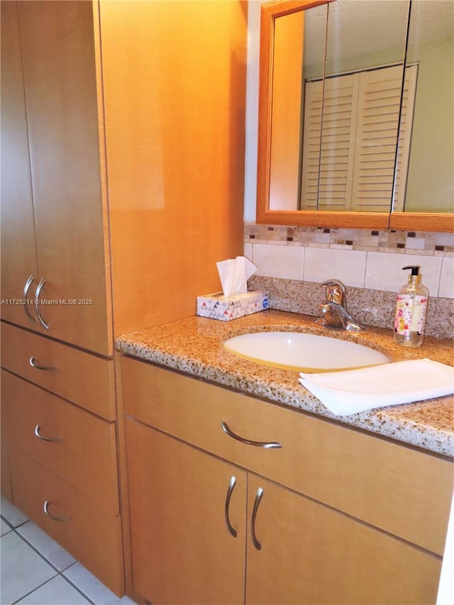 bathroom with vanity, tile patterned flooring, and tasteful backsplash