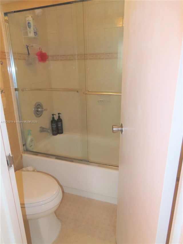 bathroom featuring shower / bath combination with glass door and toilet