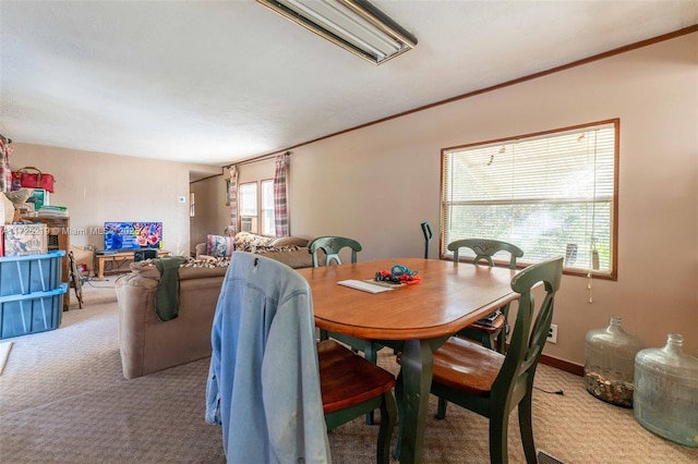 carpeted dining area with ornamental molding