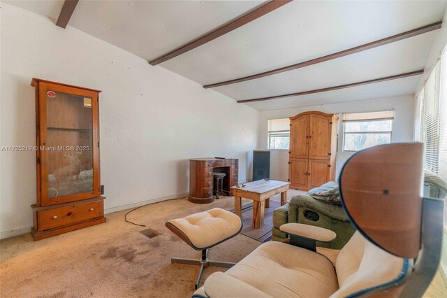 carpeted living room with beam ceiling