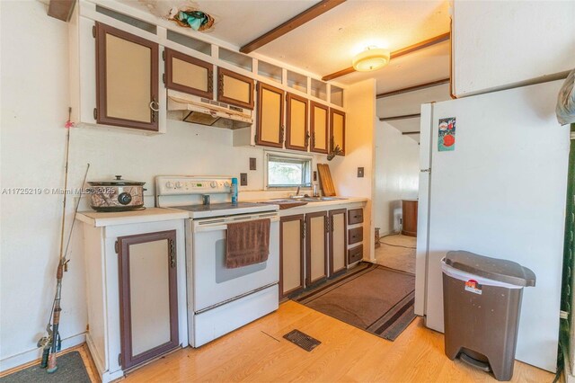 kitchen featuring sink, white appliances, and light hardwood / wood-style floors