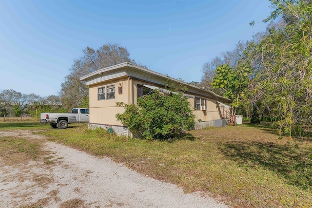 view of side of property with a yard and central AC