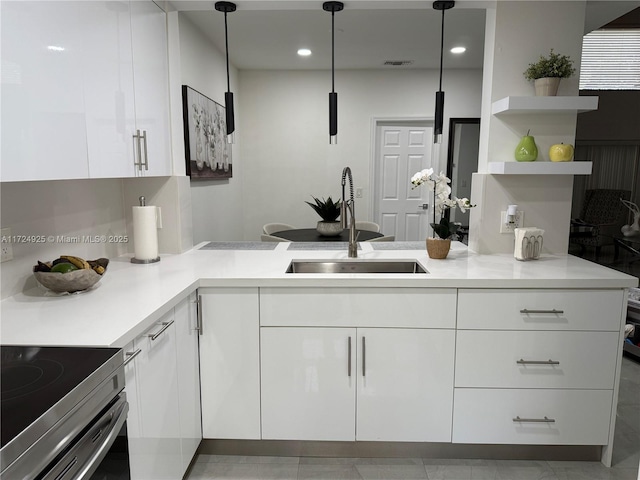 kitchen featuring hanging light fixtures, white cabinets, and sink