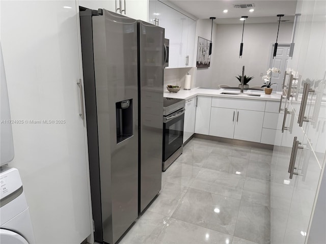 kitchen featuring hanging light fixtures, sink, stainless steel appliances, and white cabinetry