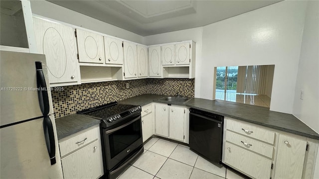 kitchen with sink, dishwasher, light tile patterned floors, stainless steel fridge, and electric stove