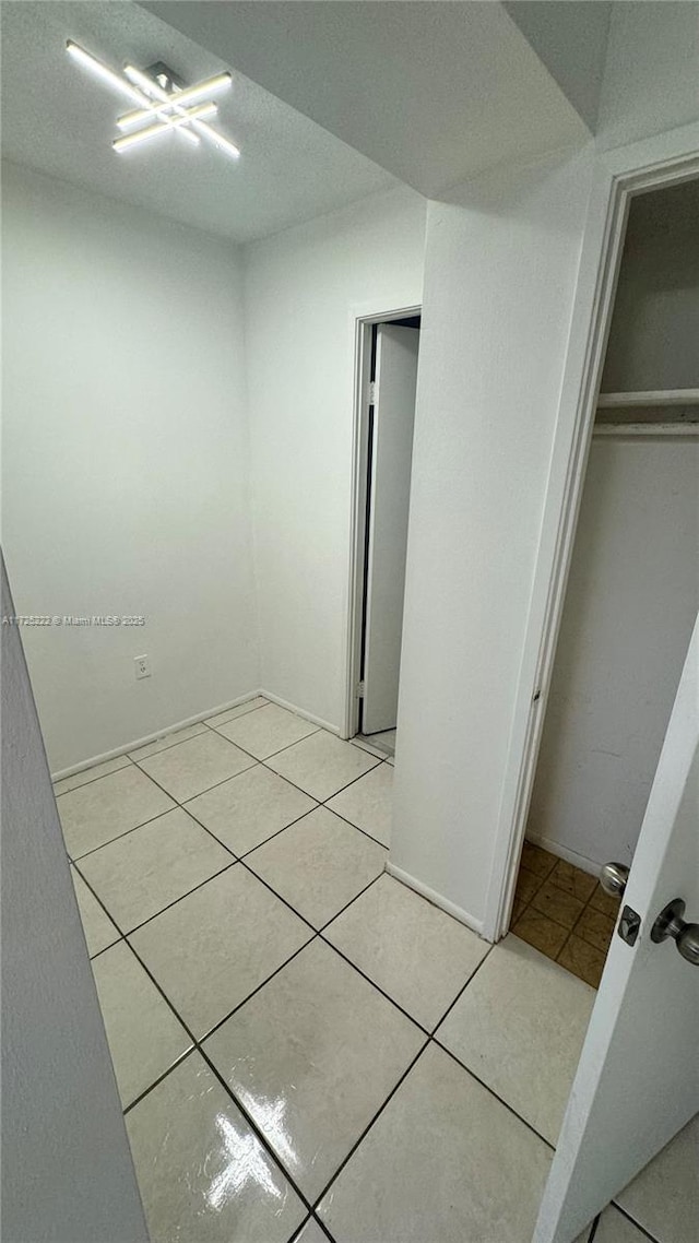 unfurnished bedroom featuring light tile patterned flooring and a closet