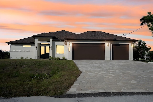 prairie-style house with a garage and a yard