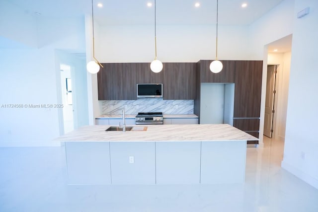 kitchen with sink, stainless steel appliances, backsplash, and pendant lighting