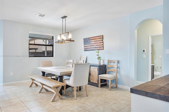 dining area with a notable chandelier and light tile patterned floors