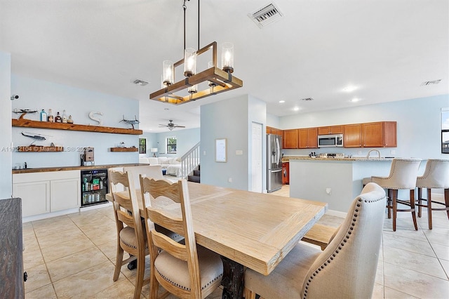 dining space with beverage cooler, ceiling fan, and light tile patterned floors