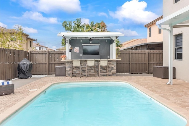 view of swimming pool with an outdoor bar and a patio