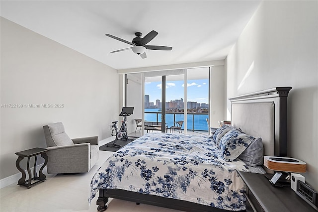 bedroom featuring ceiling fan, access to outside, and a water view