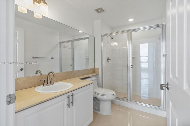 bathroom featuring tile patterned flooring, an enclosed shower, vanity, and toilet