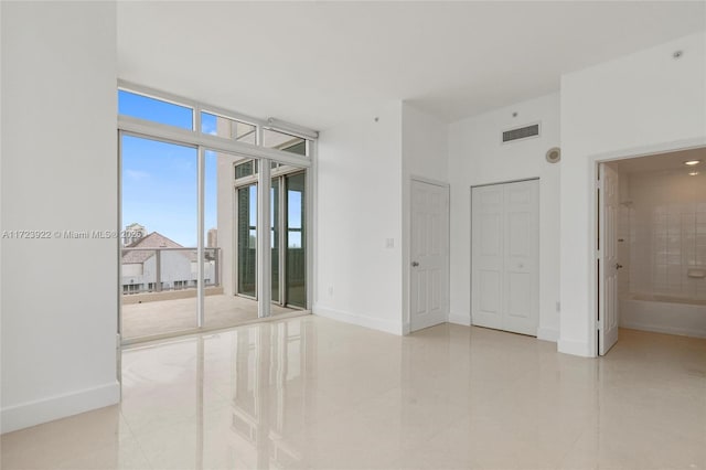 empty room with light tile patterned flooring and expansive windows