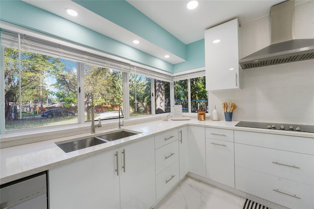 kitchen featuring sink, white cabinetry, dishwasher, wall chimney range hood, and black electric stovetop