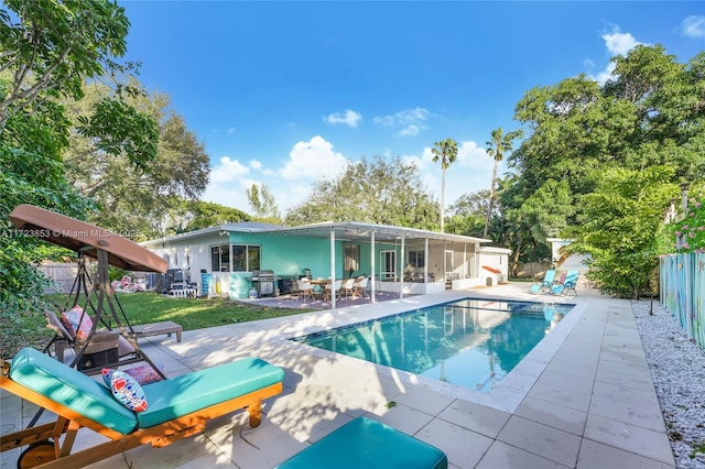 view of pool featuring a lawn, a grill, and a patio area