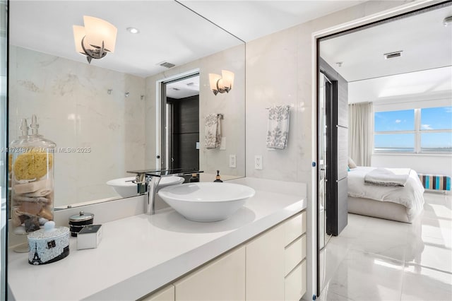 bathroom featuring vanity and tile walls