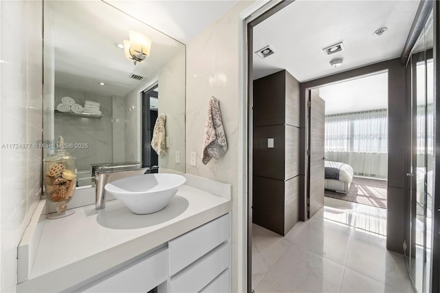 bathroom with tile walls, vanity, and tile patterned flooring