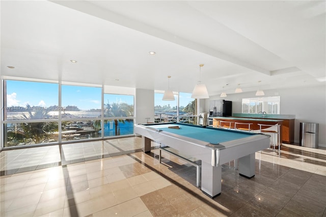 game room with a water view, a wall of windows, billiards, and light tile patterned floors