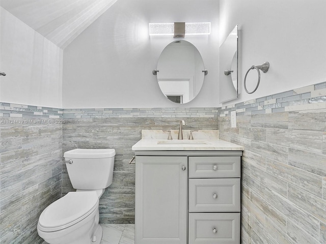 bathroom with toilet, tile walls, and vanity