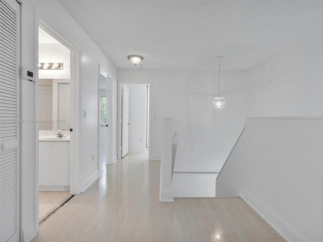 hall with sink and a textured ceiling