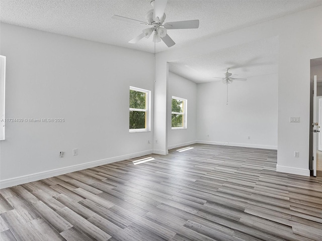 empty room featuring ceiling fan, light wood-type flooring, and a textured ceiling