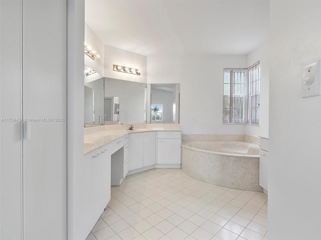 bathroom with a relaxing tiled tub, tile patterned floors, and vanity