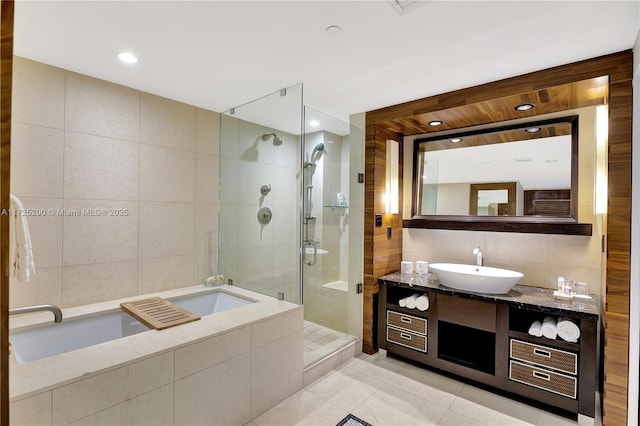 bathroom featuring tile walls, tile patterned floors, independent shower and bath, and vanity