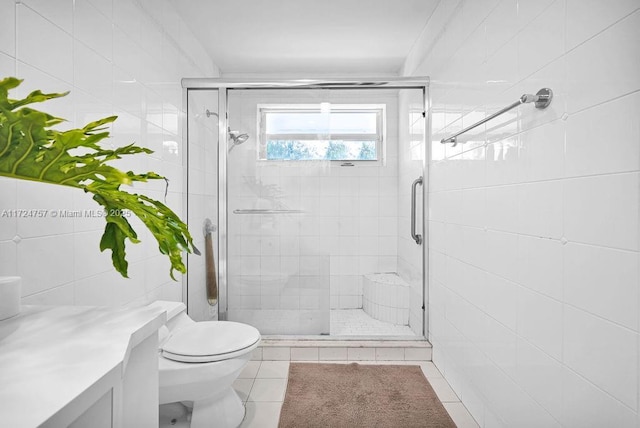 bathroom featuring tile walls, tile patterned flooring, toilet, and a shower with door