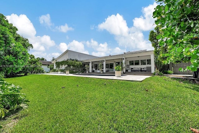 back of property featuring a patio and a yard