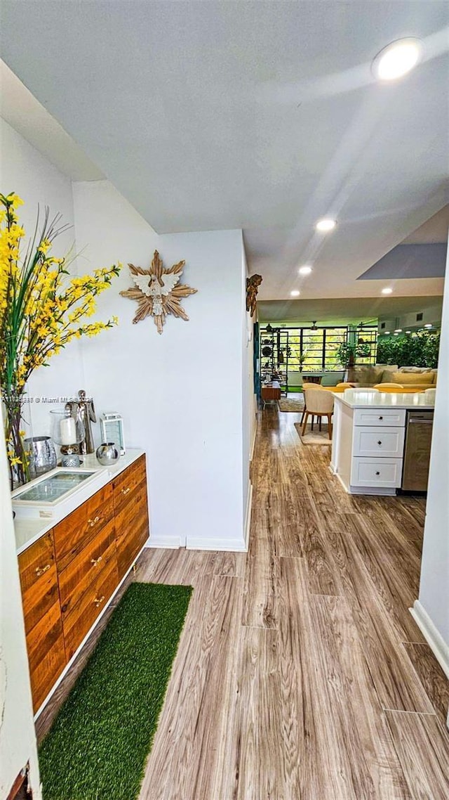 interior space with a textured ceiling, white cabinetry, and hardwood / wood-style flooring