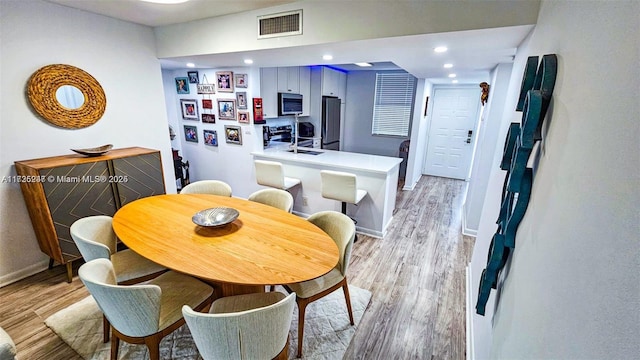 dining space featuring light hardwood / wood-style floors and sink