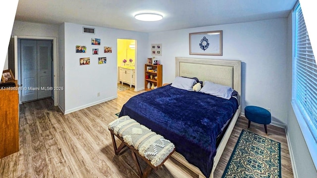 bedroom featuring connected bathroom, a closet, and hardwood / wood-style flooring