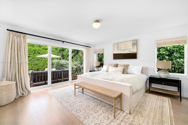 bedroom with access to outside and light wood-type flooring