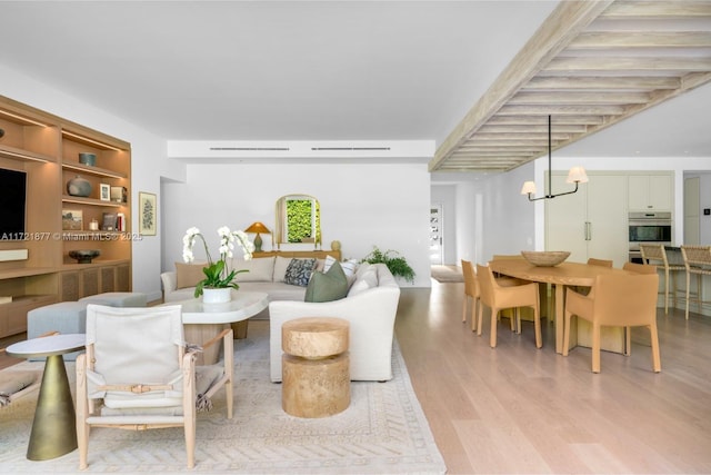 living room featuring a notable chandelier and light wood-type flooring