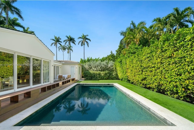 view of pool with a lawn