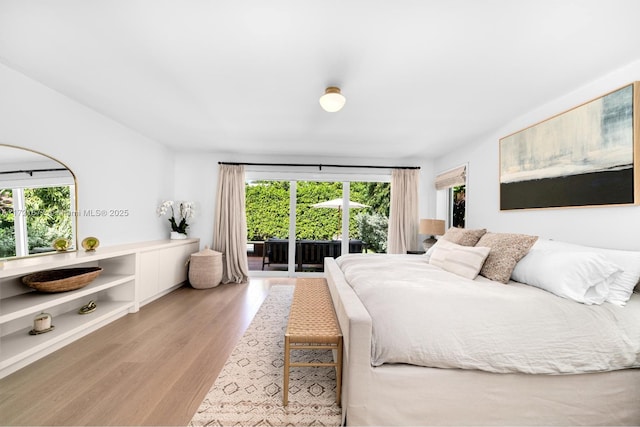 bedroom featuring access to exterior and light hardwood / wood-style flooring