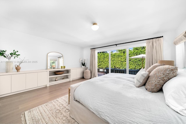 bedroom featuring access to exterior and light wood-type flooring